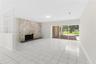 Living area featuring tile flooring, a floor-to-ceiling stone fireplace, a partial-height decorative room divider, and sliding glass doors opening to 