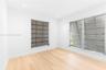 Wood-finish flooring, recessed lighting, and multiple jalousie windows