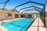 Screened lanai featuring a rectangular swimming pool, ceramic tile decking, and mounted ceiling fans