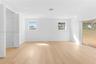 Light-filled interior featuring wood-finish flooring, recessed lighting, white louvered closet doors, and large sliding glass panels