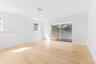 Interior space featuring light wood-finish flooring, recessed lighting, and large sliding glass doors revealing a screened-in pool enclosure