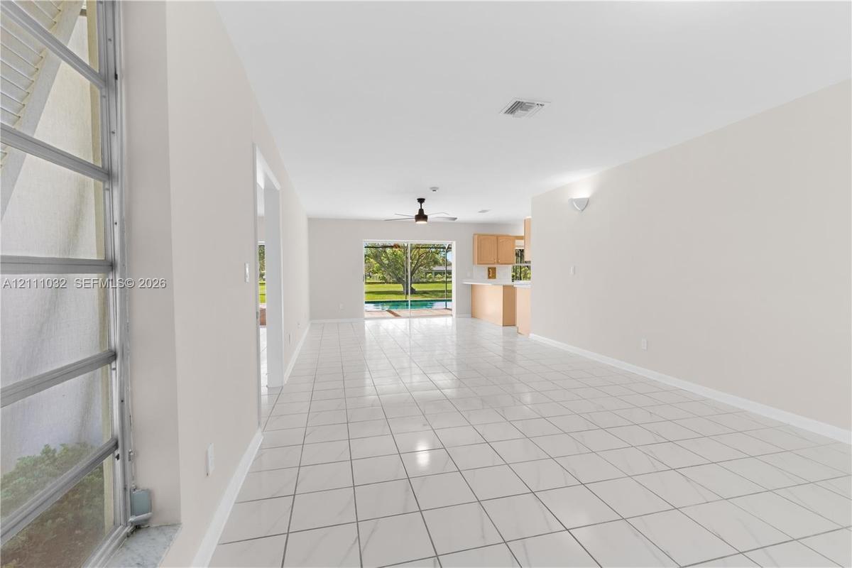 Interior space featuring large-format tile flooring, a ceiling fan, sliding glass doors, and built-in cabinetry