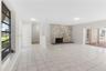 Floor-to-ceiling stone fireplace, ceramic tile flooring, decorative lattice room partition, and sliding glass doors