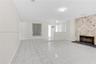 Living space featuring large-format tile flooring, a floor-to-ceiling natural stone fireplace, dark stone hearth, and a white grid-pattern partition s