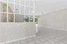 Living area featuring light-colored tile flooring, a white decorative lattice partition, and an interior stone accent wall