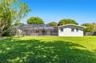 Expansive lawn, screened-in patio area, and mature trees