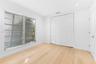 Room featuring wood-finish flooring, recessed lighting, white louvered closet doors, and multi-pane jalousie windows
