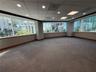 Expansive open-concept space featuring panoramic floor-to-ceiling windows, high-contrast dark wood-finish trim, recessed ceiling lighting, and wall-to