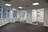Expansive workspace featuring large windows with grid detailing, built-in lower cabinetry, a drop ceiling with integrated recessed lighting, and glass