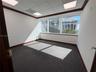 Office space featuring floor-to-ceiling windows, dark-tone carpeting, suspended grid ceiling panels, recessed lighting, and dark wood-finish crown mol