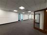 Expansive interior space featuring a drop ceiling with recessed lighting, wall-to-wall carpeting, and wood-framed doors with glass panels