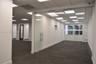 Interior space featuring floor-to-ceiling glass wall partitions, a frameless glass entry door with stainless steel hardware, drop ceiling with recesse