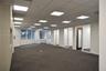 Open-concept interior featuring a grid-pattern drop ceiling with recessed LED lighting, wall-to-wall carpeting, multiple glass-paneled entryways, and 