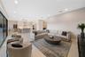 Open-concept interior featuring large-format tile flooring, recessed ceiling lighting, sliding glass doors, and a kitchen equipped with a center islan