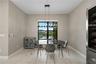 Dining area featuring large-format tile flooring, a linear multi-light pendant fixture, and a built-in stainless steel wine refrigerator