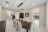 Dining area featuring oversized tile flooring, recessed lighting, and a multi-light linear pendant fixture, including a built-in floor-to-ceiling cabi