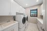 Laundry room featuring white cabinetry, a composite utility sink, quartz countertops, recessed lighting, and tile flooring