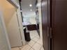 Kitchen featuring dark wood-finish cabinetry, built-in stainless steel double wall ovens, a gooseneck faucet, and diagonal-set tile flooring
