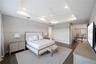 Tray ceiling with recessed lighting, central ceiling fan, and dark wood-finish flooring