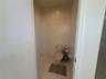 Enclosed water closet featuring light-toned tile flooring and neutral wall finishes