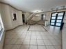 Interior space featuring diagonal tile flooring with decorative inlay, double-entry door with frosted glass panes, staircase with vertical balusters, 