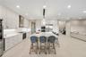 Contemporary kitchen featuring ceiling-height flat-panel cabinetry, a central island with a stone-finish countertop, stainless steel built-in applianc