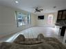 Open-concept space featuring large-format ceramic tile flooring, recessed lighting, ceiling fan, and crown molding