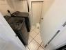 Laundry room featuring diagonal-set floor tile, textured wall finishes, and a bifold closet door