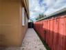 Stucco exterior featuring a paved patio, inground pool with integrated spa, and a wooden pergola