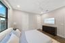 Neutral-toned interior featuring floor-to-ceiling windows, wood-finish flooring, a ceiling fan with integrated lighting, and solid-core doors
