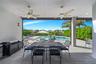 Covered patio featuring large-format tile flooring, dual ceiling fans, and recessed lighting, overlooking a private swimming pool with a stone water f