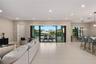 Open-concept interior featuring large-format tile flooring, recessed ceiling lighting, and expansive multi-panel sliding glass doors opening to a cove