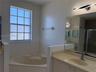 Bathroom featuring an integrated oval soaking tub with a tile surround, vanity with a solid-surface countertop and undermount sink, large wall-mounted