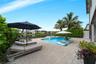 Screened swimming pool and spa with stone paver decking, finished with perimeter landscaping and water frontage