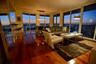 Open-concept living space featuring wood-finish flooring, floor-to-ceiling glass windows, and a built-in breakfast bar