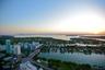 Aerial perspective overlooking coastal waterways, a bridge, metropolitan high-rises, and extensive harbor scenery