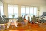 Open-concept interior featuring floor-to-ceiling windows, wood-finish flooring, and a contemporary multi-bulb chandelier