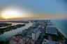 High-altitude coastal panorama featuring an expansive shoreline, an inlet waterway, and sunset horizon