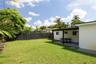 Backyard space featuring a covered patio, manicured lawn, and privacy fencing