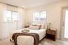 Neutral-toned interior featuring wood-finish flooring, dual sliding windows, and a glass-paneled exterior door