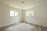 Neutral interior room featuring wood-finish flooring, recessed lighting, and dual sliding windows