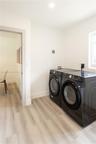 Laundry room featuring wood-finish flooring, white walls, and a recessed ceiling light