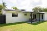 Exterior features include a covered patio, paved hardscaping, a fenced yard, and a shingled roof