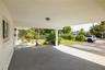 Covered carport with a concrete floor, integrated ceiling lighting, and exposed support pillar