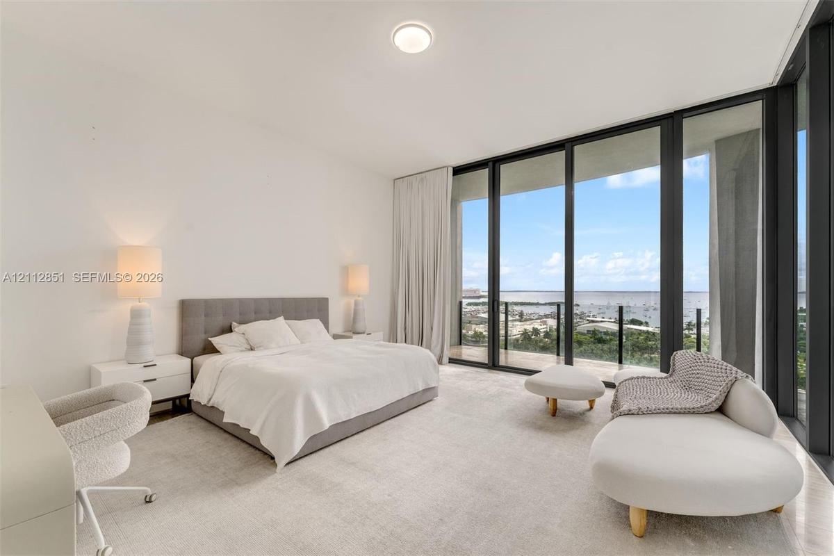 Floor-to-ceiling windows, sliding glass door, private balcony, neutral wall-to-wall carpeting, and recessed ceiling lighting