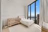 Floor-to-ceiling windows featuring expansive coastal and marina scenery, complemented by light-toned wood-finish flooring