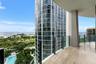 Covered balcony featuring stone flooring and a glass panel railing