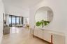 Open-concept interior featuring light-toned tile flooring, recessed ceiling lighting, and floor-to-ceiling glass panel walls