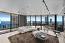Floor-to-ceiling glass walls, wrap-around private terrace, smooth-finish ceiling with track lighting, and large-format tile flooring
