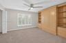 (FAN VIRTUALLY STAGED AS SIMILAR PIECE WILL BE INSTALLED) Custom light-toned built-in cabinetry, window with plantation shutters, ceiling fan with int